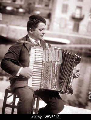 1920s SMILING DARK HAIR HANDSOME MAN ANONYMOUS MUSICIAN PLAYING A PIANO STYLE SQUEEZEBOX ACCORDION ITALY - c4093 HAR001 HARS PERSONS INSPIRATION MALES ENTERTAINMENT B&W PERFORMING ARTS DREAMS HAPPINESS ACCORDION CHEERFUL EXCITEMENT RECREATION HANDSOME ITALY PRIDE A OCCUPATIONS SMILES CONCEPTUAL DARK HAIR JOYFUL STYLISH ACCORDIONIST ANONYMOUS CREATIVITY RELAXATION YOUNG ADULT MAN BELLOWS BLACK AND WHITE CAUCASIAN ETHNICITY HAR001 OLD FASHIONED SQUEEZEBOX Stock Photo