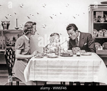 1930s 1940s FAMILY MOTHER FATHER DAUGHTER AT DINING TABLE LITTLE GIRL PLAYFULLY FEEDING HER FATHER - d110 HAR001 HARS DAD DINING MOM EAT CLOTHING INDOORS NOSTALGIC PAIR HER MOTHERS OLD TIME NOSTALGIA OLD FASHION 1 FEEDING JUVENILE STYLE COMMUNICATION YOUNG ADULT STRONG FAMILIES JOY LIFESTYLE SATISFACTION FEMALES MARRIED STUDIO SHOT SPOUSE HUSBANDS HEALTHINESS HOME LIFE COPY SPACE FRIENDSHIP HALF-LENGTH LADIES DAUGHTERS PERSONS CARING MALES FATHERS B&W PARTNER SUIT AND TIE HAPPINESS DADS CONNECTION DINNERS STYLISH PERSONAL ATTACHMENT AFFECTION COOPERATION DINE EMOTION GROWTH JUVENILES MOMS Stock Photo