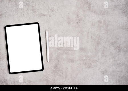 Black digital tablet with blank screen and pencil on grey concrete table. Flat lay. Copy space for text. Stock Photo