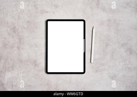 Black digital tablet with blank screen and pencil on grey concrete table. Flat lay. Copy space for text. Stock Photo
