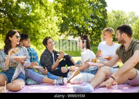 happy friends eating sandwiches at summer picnic Stock Photo