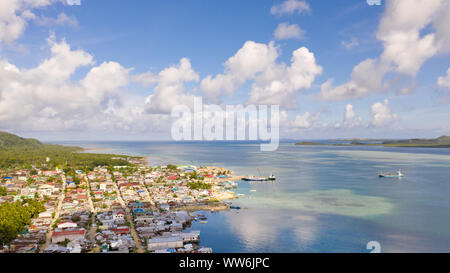 Sea port in the city of Dapa, Philippines. Fishing village and ships, view from above. Seascape in sunny weather. Stock Photo