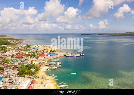 Sea port in the city of Dapa, Philippines. Fishing village and ships, view from above. Seascape in sunny weather. Stock Photo