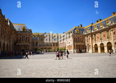 Paris / France - July 6, 2019: Groups of tourists in main square of Versailles Palace, summer time. Stock Photo