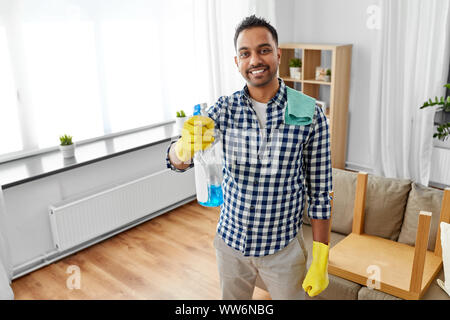 smiling indian man with detergent cleaning at home