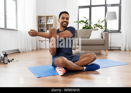 man training and stretching arm at home Stock Photo
