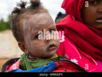 Oromo toddler with her mother in Sheikh Hussein shrine with jarawa powder on the face, Oromia, Sheik Hussein, Ethiopia Stock Photo