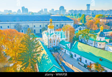 KIEV, UKRAINE - OCTOBER 18, 2018: The entrance alley surrounded with medieval corps and beautiful the Gate Church of the Trinity with large frescoes, Stock Photo