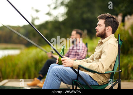friends fishing and drinking beer at lake Stock Photo - Alamy