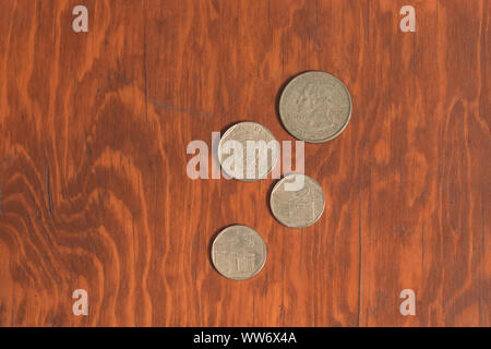 Monterrey, Mexico - Sept 11, 2019: Cuban currency, cuc, worth five cents, ten cents and US currency worth twenty-five cents on a wooden desktop. Colle Stock Photo