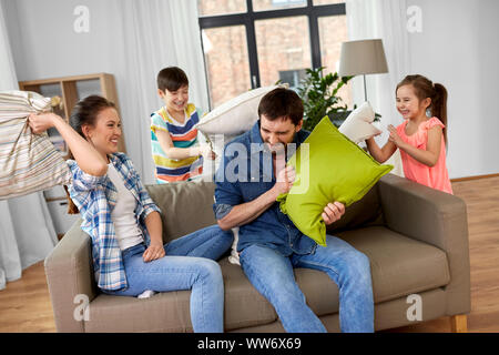 happy family having pillow fight at home Stock Photo
