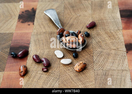 Beans, mixed beans, legumes, wooden board, spoon Stock Photo