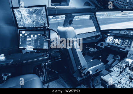 Cockpit of airliner simulator. Switches and dials visible in the background. Stock Photo