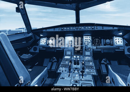 Cockpit of airliner simulator. Switches and dials visible in the background. Stock Photo