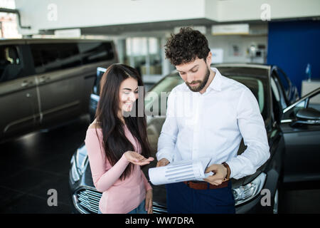 happy woman buying a new car at vehicle showroom Stock Photo