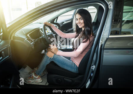 Woman Driver Holding Car Keys. Car Showroom. Stock Photo