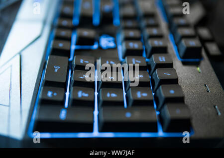 Gamer keyboard with colorful blue lights, modern gamer computer. Blue backlight, backlit on laptop or keyborad computer of gaming. Stock Photo