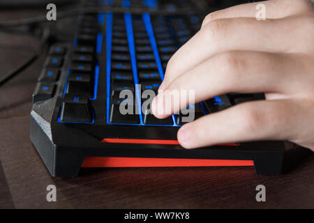 Gamer keyboard with colorful blue lights, modern gamer computer. Blue backlight, backlit on laptop or keyborad computer of gaming. Stock Photo