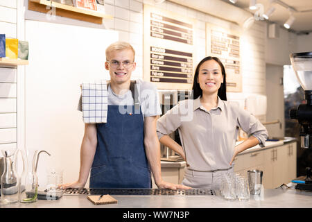 Two young successful workers of contemporary cafe or restaurant in uniform Stock Photo