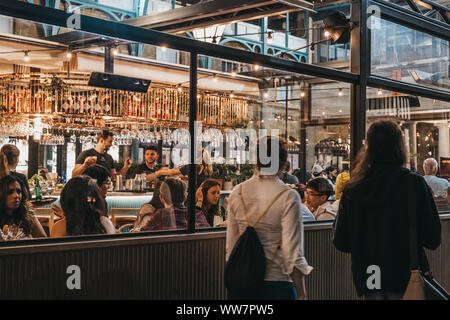 London, UK - August 31, 2019: Women walking past the windows of Buns and Buns restaurant in Covent Garden Market, one of the most popular tourist site Stock Photo