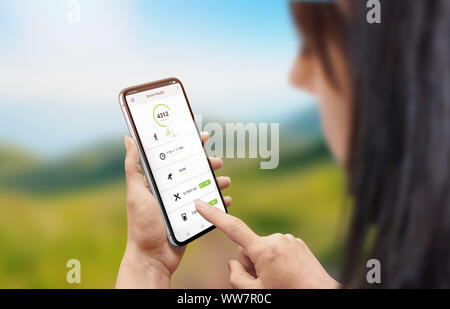 Smart health app on mobile phone in woman hand. Girl use smart phone to monitoring steps, calories, heart rate. Stock Photo