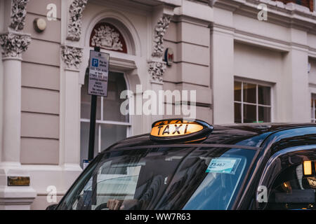 London, United Kingdom - August 31, 2019: Close up of an illuminated taxi sign on a black cab in London, UK. London taxis are an important part of the Stock Photo