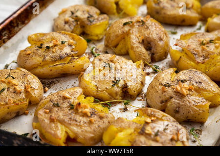 Homemade garlic thyme smashed potatoes, side view. Close-up. Stock Photo