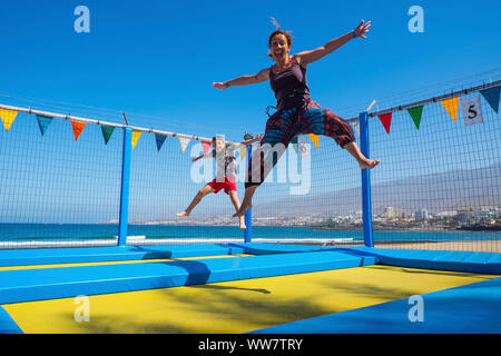 mother and young child son caucasian playing and jumping like crazy having a lot of fun in vacation. outdoor leisure activity for beautiful family and people Stock Photo