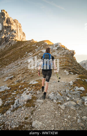 A young man running downhill to the valley Stock Photo