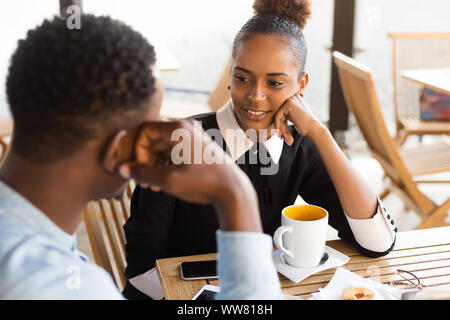 Black  African American coworkers doing digital teamwork arround a coffee cup Stock Photo