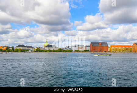 The dome of Frederik's Church, also known as the Marble Church rises above the city of Copenhagen as a tour boat cruises along the canal in Denmark. Stock Photo