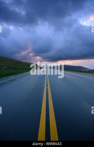 Morning Light Glows Through Clouds Over Rainy Road on Big Sur Stock Photo