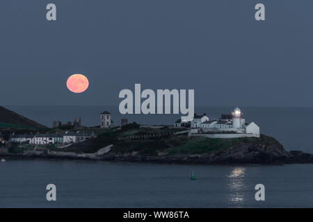 Roches Point, Cork, Ireland. 13th September, 2019. A full harvest making its annual appearance rising over the Roches Point Lighthouse in Co. Cork, Ireland.  - Credit;  David Creedon / Alamy Live News
