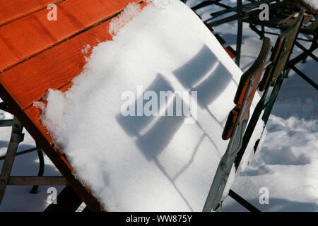 Shadow of two chair backs on snow-covered beer table Stock Photo