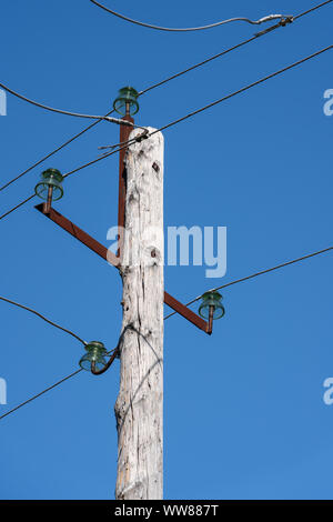 Old wooden high voltage post or high voltage tower in sunny day on clear cloudless sky Stock Photo