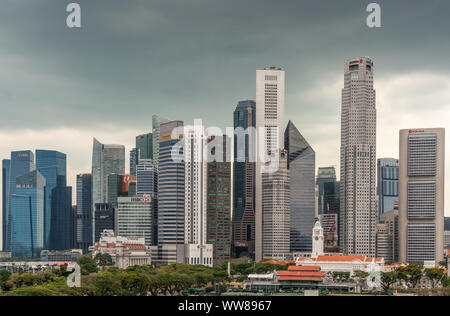 Singapore - March 20, 2019: Line of financial district skyscrapers from DBS to OCBC bank buildings under dark gray cloudscape. Victoria theatre and Cr Stock Photo