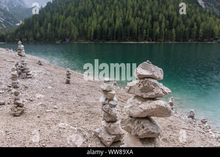 Autumn hike around the Pragser Wildsee in the Dolomites, Italy, cairn on the shore Stock Photo