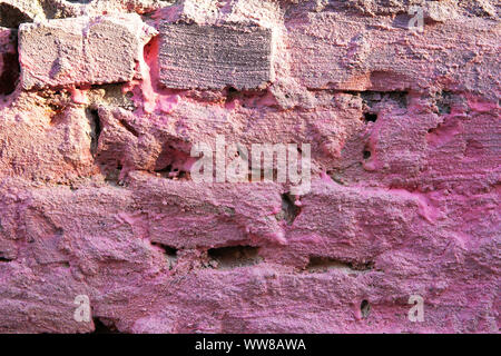 Crumbling painted pink brick wall texture. Backround. Stock Photo