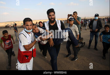 Khan Younis, Gaza. 13th Sep, 2019. Palestinian paramedics carry away an injured protester during clashes with Israeli forces across the barbed-wire fence following a demonstration along the border with Israel east of Khan Yunis in the southern Gaza, on Friday, September 13, 2019.29Palestinians wounded by the Israeli army, a medical source said. Photo by Ismael Mohamad/UPI. Credit: UPI/Alamy Live News Stock Photo