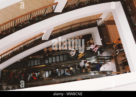 A crowd of people on the escalator in the shopping center. View from above. Stock Photo