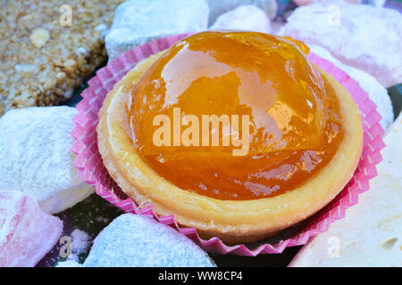 Candied orange in punnet of dough served with Turkish delight and and halva, close up view Stock Photo