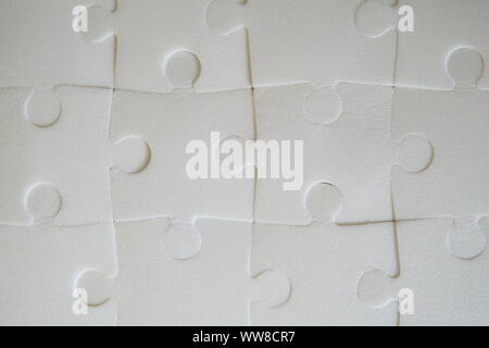 Multiple white puzzle pieces put together. View from above. Stock Photo