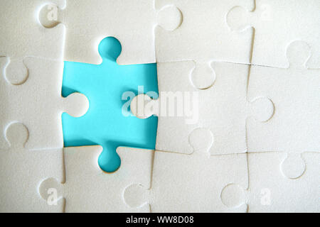 Multiple white puzzle pieces put together without one piece. View from above. Close up image. Stock Photo