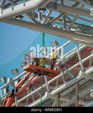 Bergamo Italy 12 September 2019: Workers working on elevating platform while restoring the lighting lamps of the Bergamo stadium Stock Photo