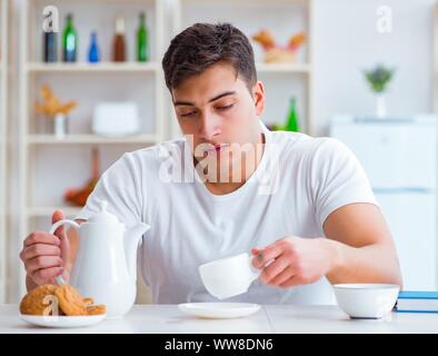 The man falling asleep during his breakfast after overtime work Stock Photo