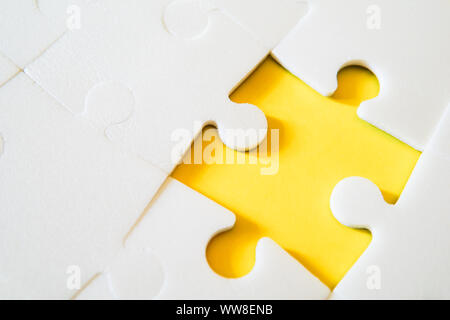 Multiple white puzzle pieces put together without one piece. View from above. Stock Photo