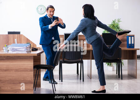 The two employees doing sport exercises in the office Stock Photo