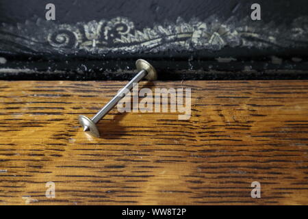 close up of single, empty sewing machine bobbin for boat shuttle style antique machine Stock Photo