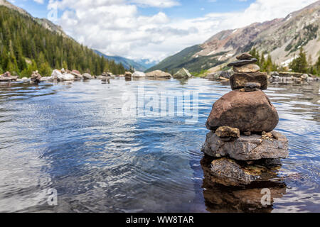 Hot springs pool and rock stack cairn on Conundrum Creek Trail in Aspen, Colorado in 2019 summer with valley view with nobody Stock Photo