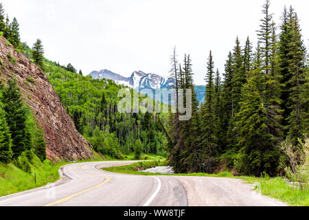 Road highway 133 in Redstone, Colorado during summer with empty street, snow mountain peak and green trees Stock Photo